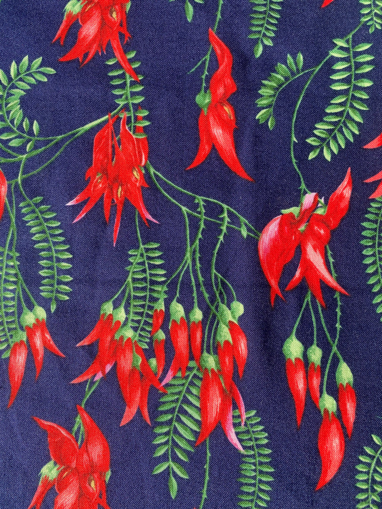 Cafe style tablecloth - reflecting vibrant red Kakabeak native NZ flowers. The background is a deep navy. Suit round or square cafe tables. 